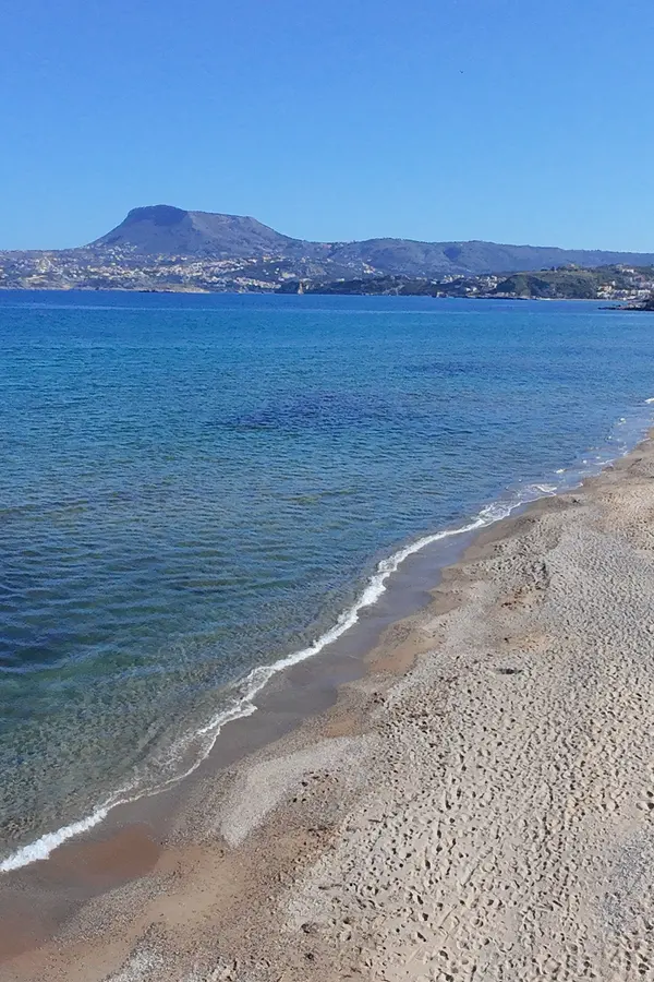 Sandy expanse and clear turquoise waters at Kiani Akti Beach, a picturesque spot on the coast of Crete.